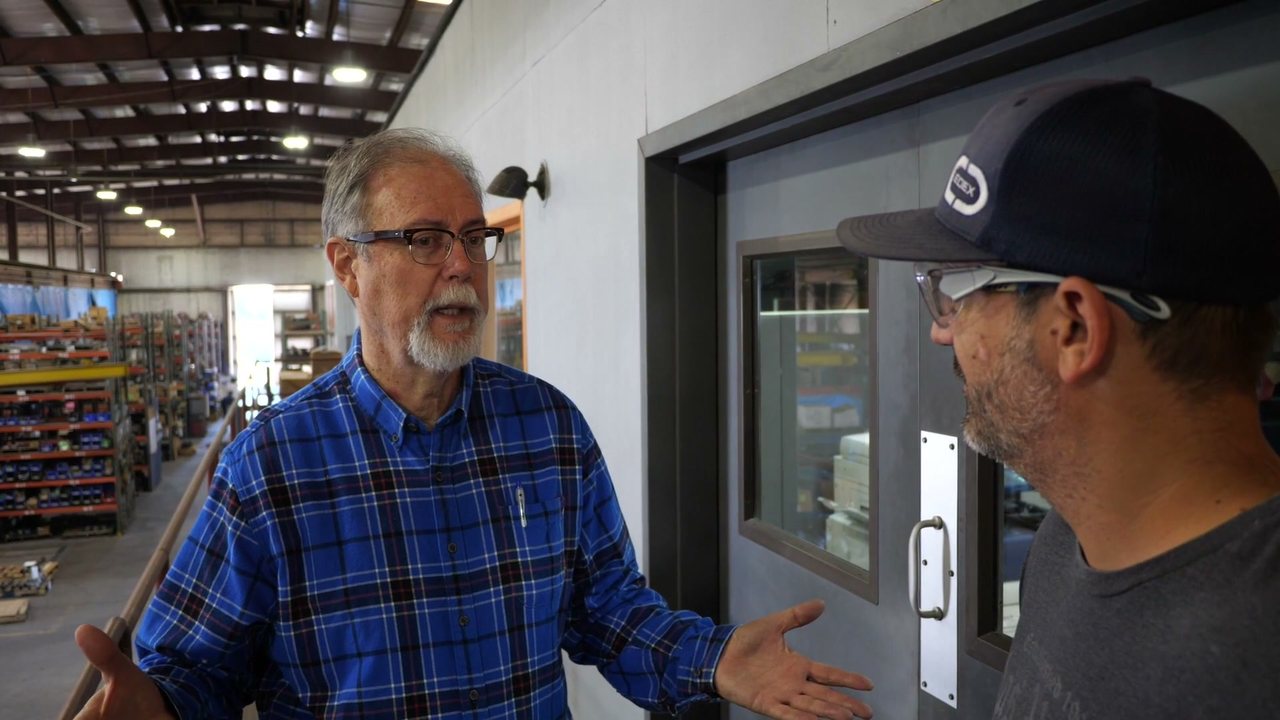 John Rogers, founder of Performance Pulsation Control, talking with an employee on the shop floor